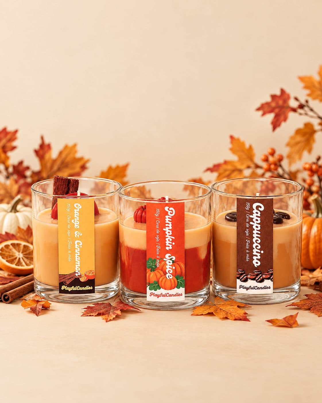 Velas Orange & Cinnamon, Pumpkin Spice e Cappuccino entre folhas de outono, abóboras, paus de canela e laranja seca